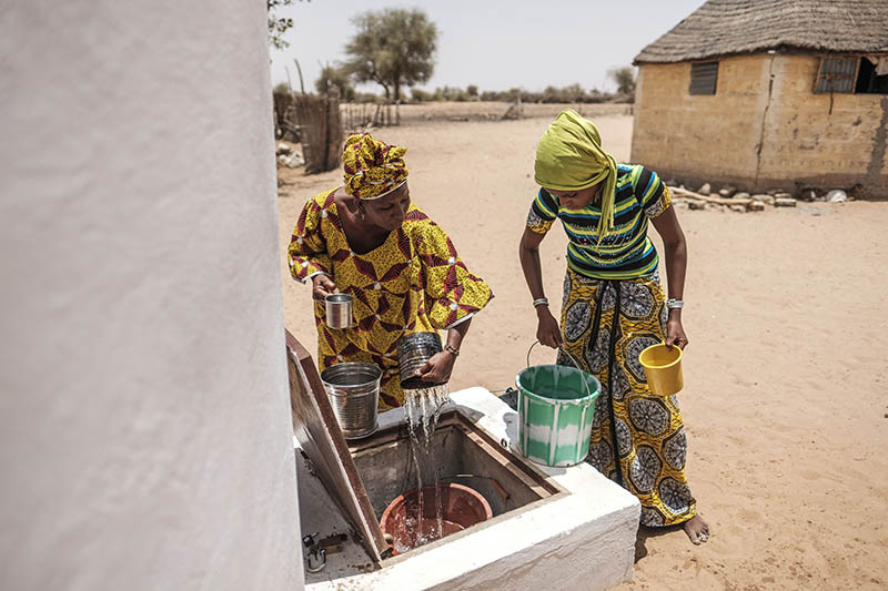 SENEGAL - Two women collecting water from a cistern.